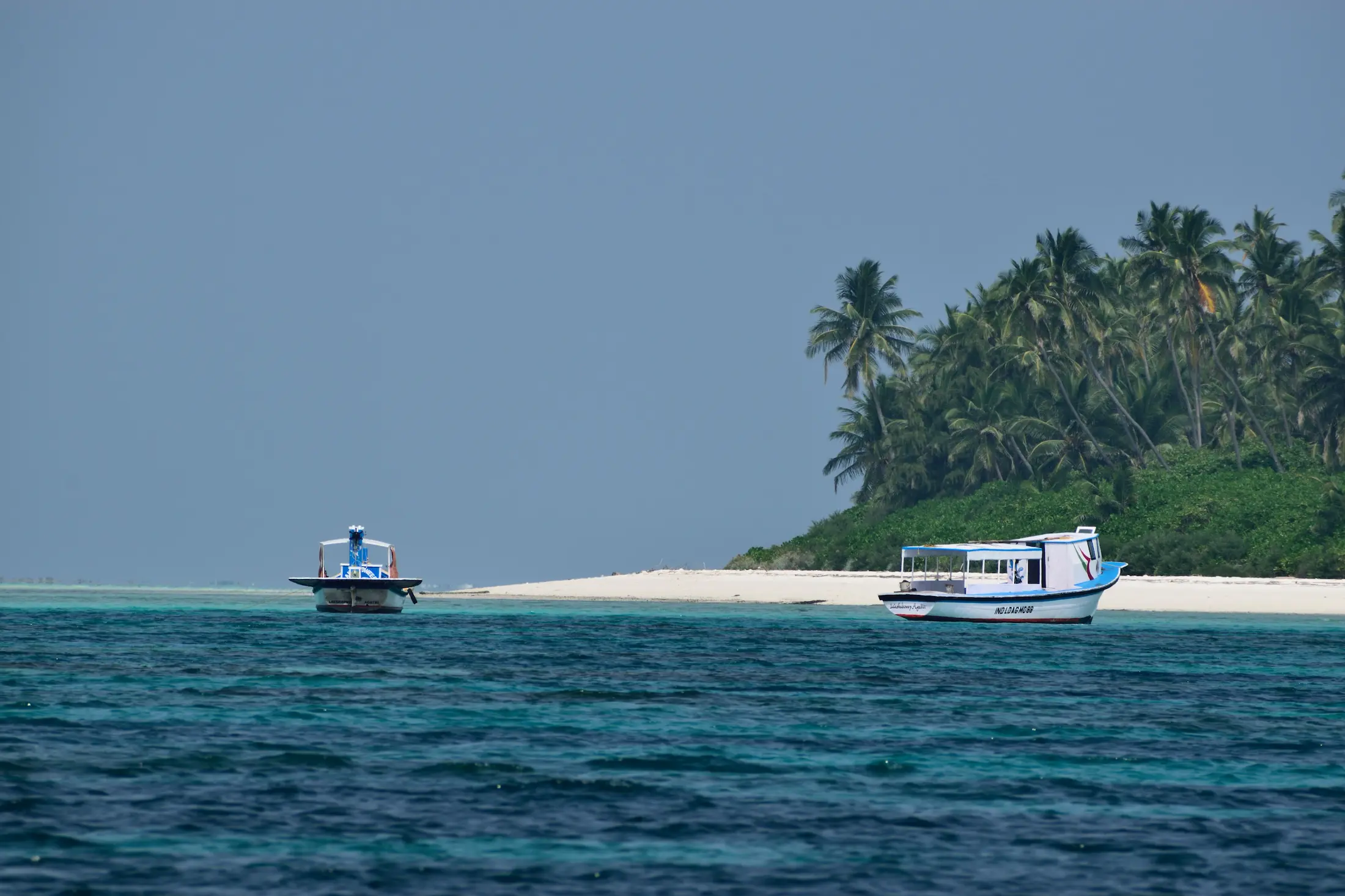 Barche davanti a una spiaggia tropicale nel tour Laccadive